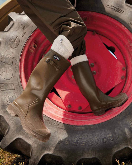 Khaki coloured Aigle Mens Cessac Gardening Wellingtons on outdoor background #colour_khaki
