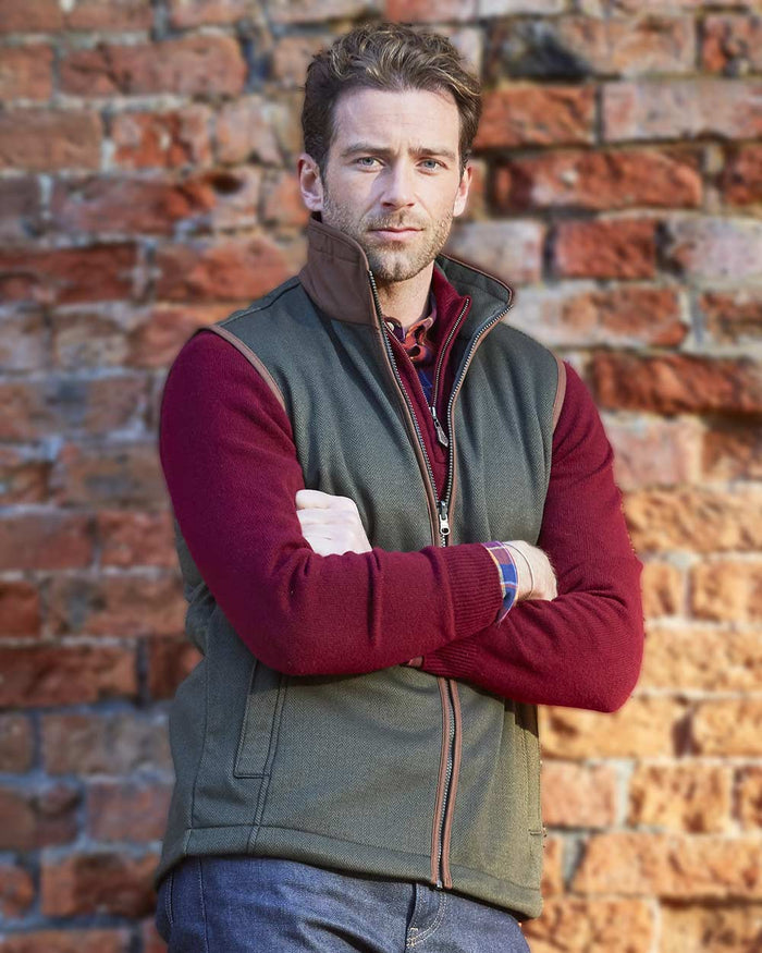 Green Herringbone coloured Alan Paine Aylsham Fleece Jacket on brick wall background #colour_green-herringbone