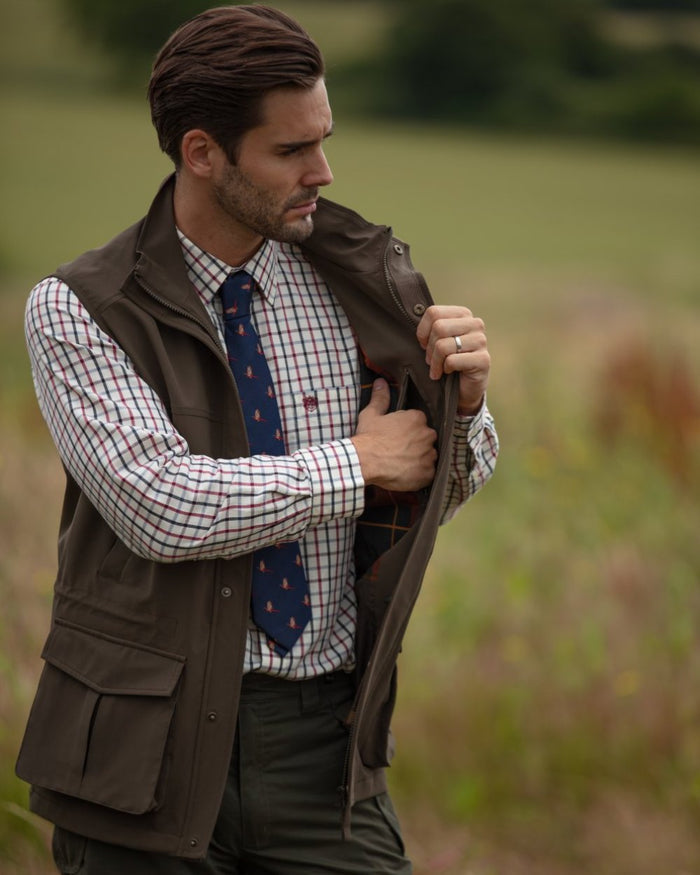 Olive coloured Alan Paine Lockwood Mens Shooting Waistcoat on blurry field background #colour_olive