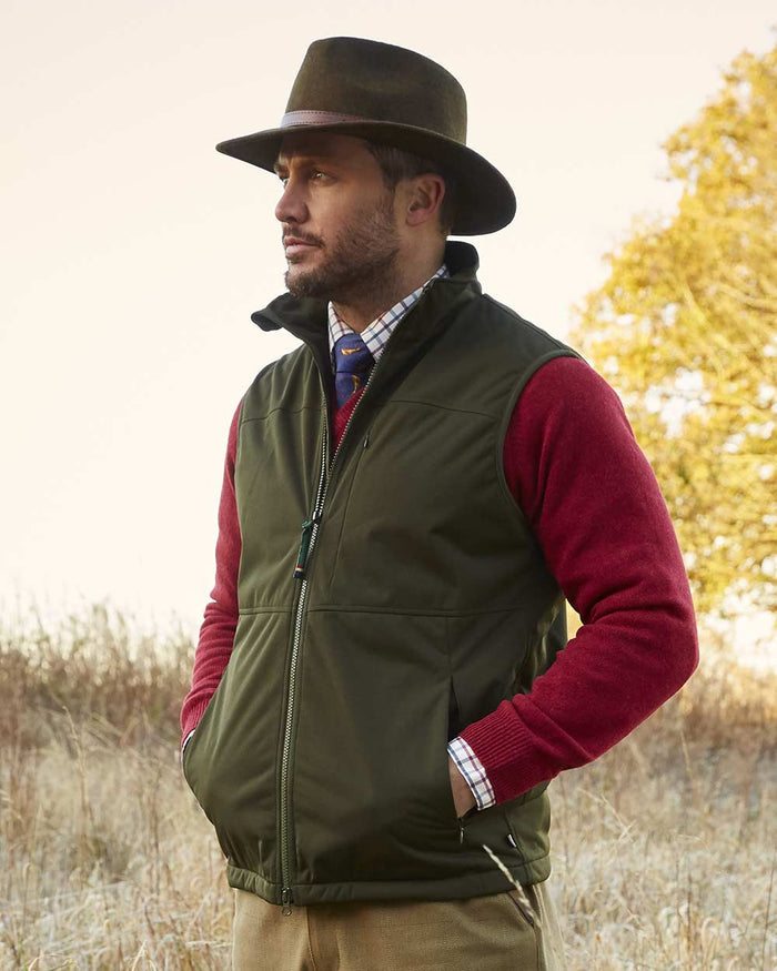 Man wearing Olive coloured Alan Paine Mossley Mens Windstopper Gilet countryside background #colour_olive