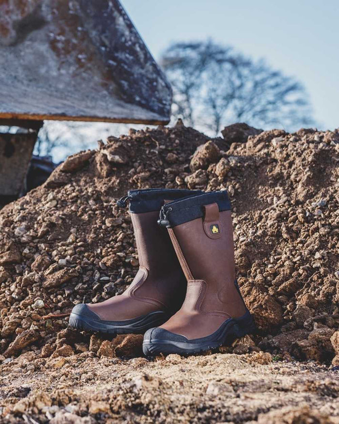 Brown Coloured Amblers Safety FS245 Antistatic Pull On Safety Rigger Boots on a muddy background #colour_brown