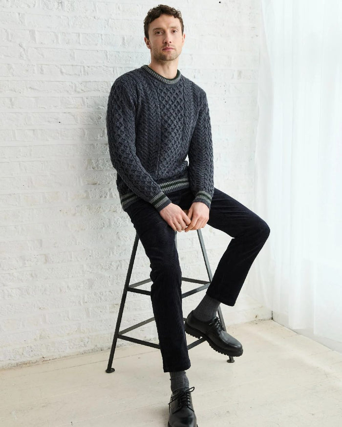 Dark Grey Coloured Aran Mens Inishbeg Stripe Crewneck Merino Sweater on indoor background #colour_dark-grey
