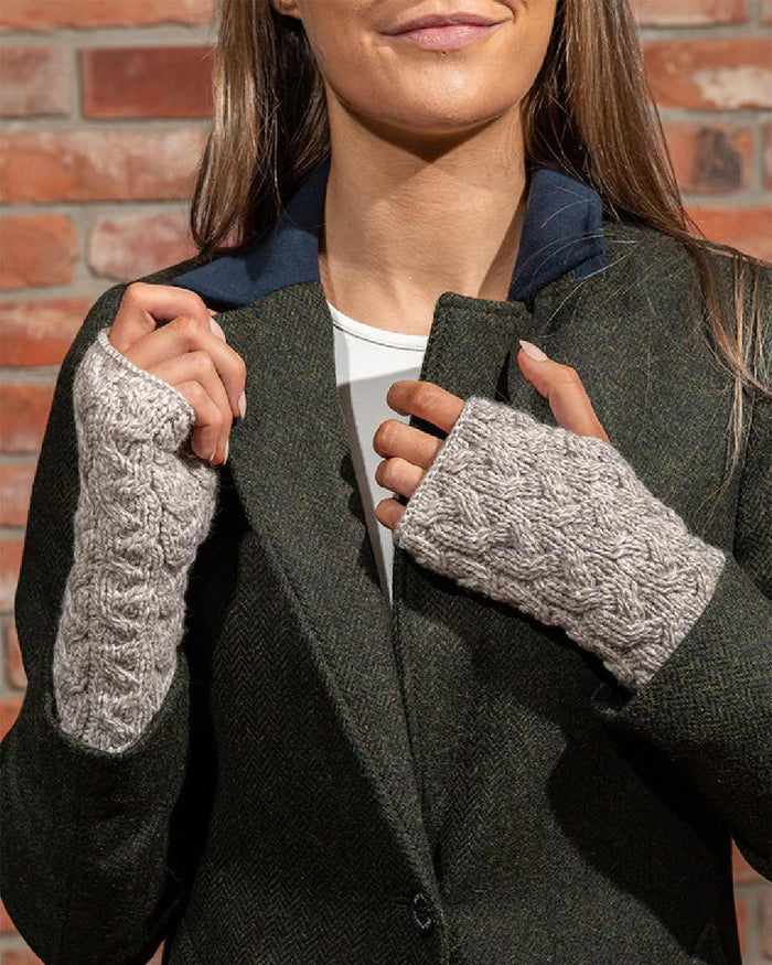 Oat Coloured Aran Supersoft Merino Fingerless Gloves on wall background #colour_oat