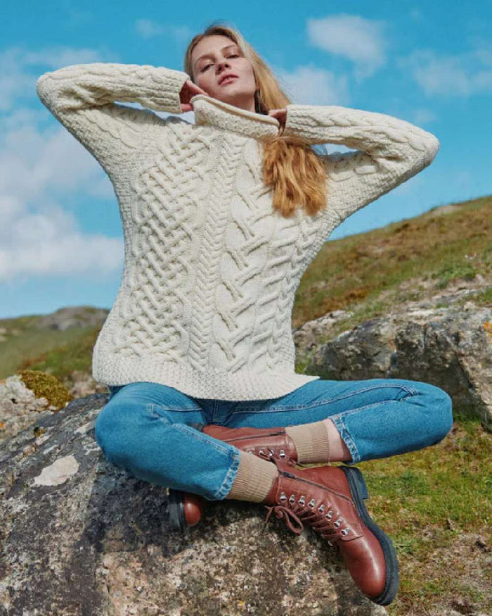Cream Coloured Aran Womens Calla Aysmmetrical Pattern Sweater on outdoor background #colour_cream
