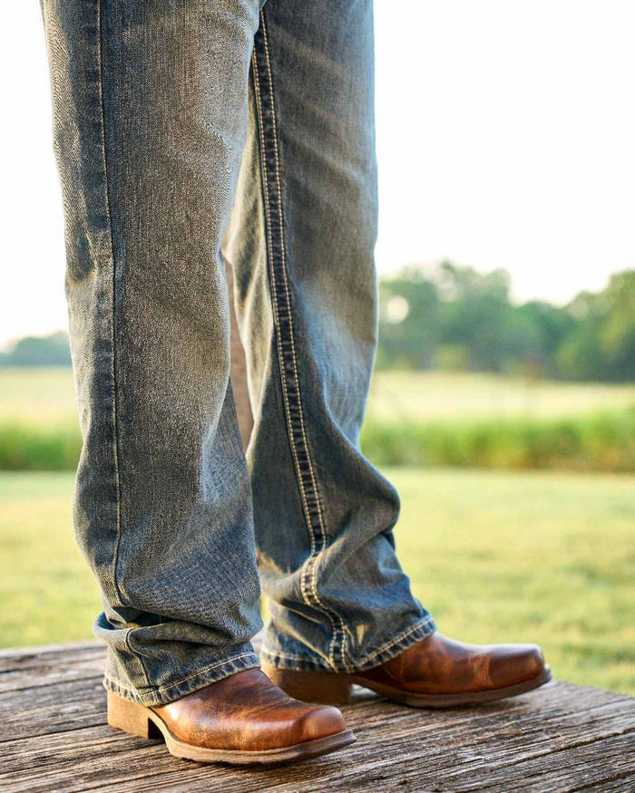 Barn Brown Coloured Ariat Mens Midtown Rambler Western Boots on countryside background #colour_barn-brown
