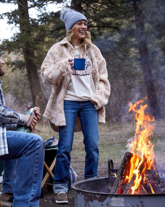 Mackenzie coloured Ariat Womens Real Perfect Rise Abby Straight Jeans on forest background #colour_mackenzie