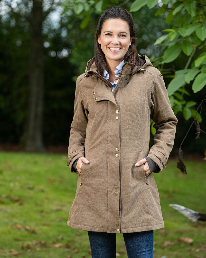 Camel Coloured Baleno Brooklands Waterproof Coat on forest background #colour_camel