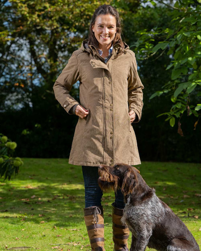 Camel Coloured Baleno Brooklands Waterproof Coat on forest background #colour_camel