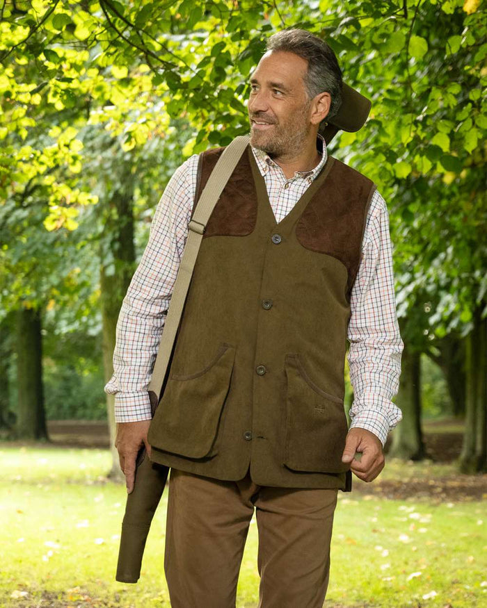 Pine Green Coloured Baleno Dolman Gilet on garden background #colour_pine-green