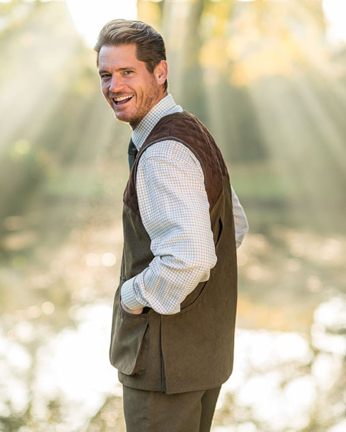 Pine Green Coloured Baleno Dolman Gilet on blurry background #colour_pine-green