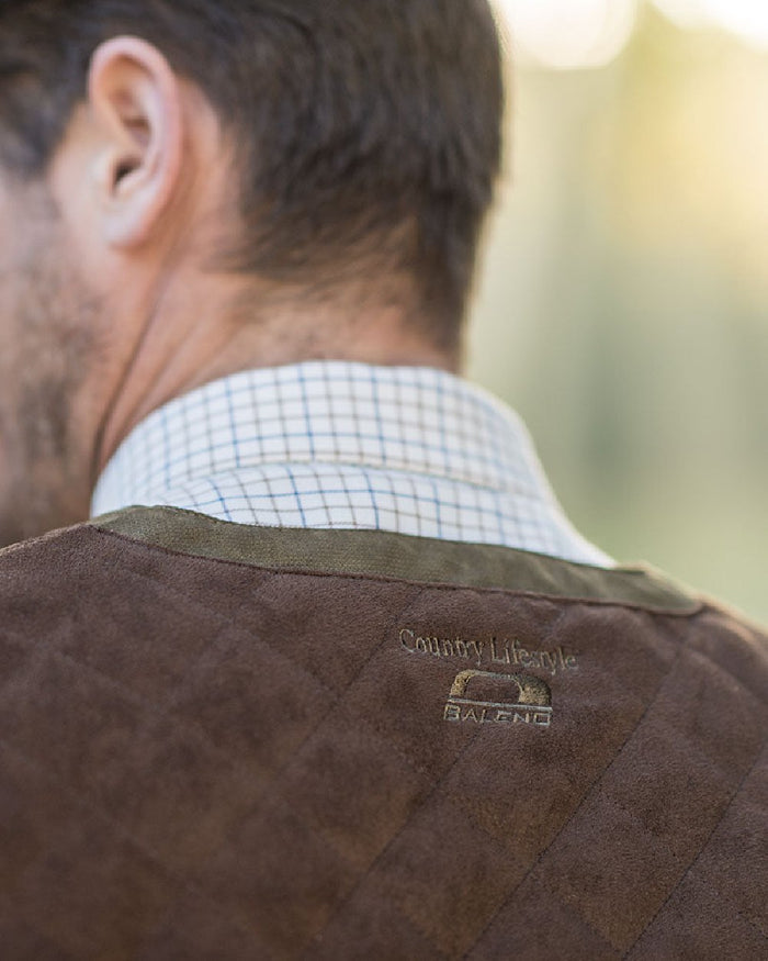 Pine Green Coloured Baleno Dolman Gilet on blurry background #colour_pine-green