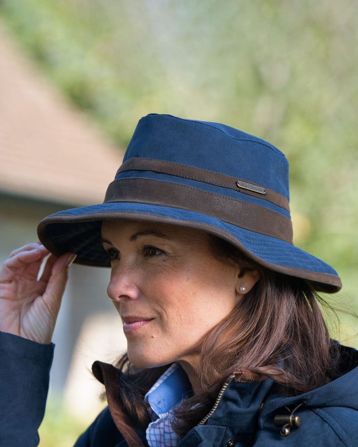 Navy Blue Coloured Baleno Edith Waterproof Hat on blurry background #colour_navy-blue
