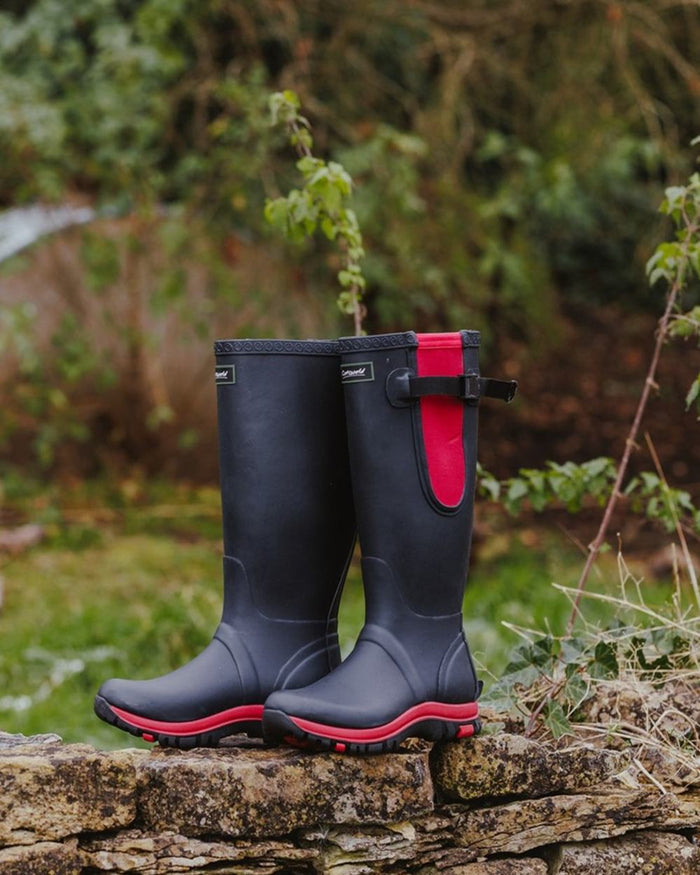 Navy Pink coloured Cotswold Womens Milton Adjustable Wellingtons on forest background #colour_navy-pink