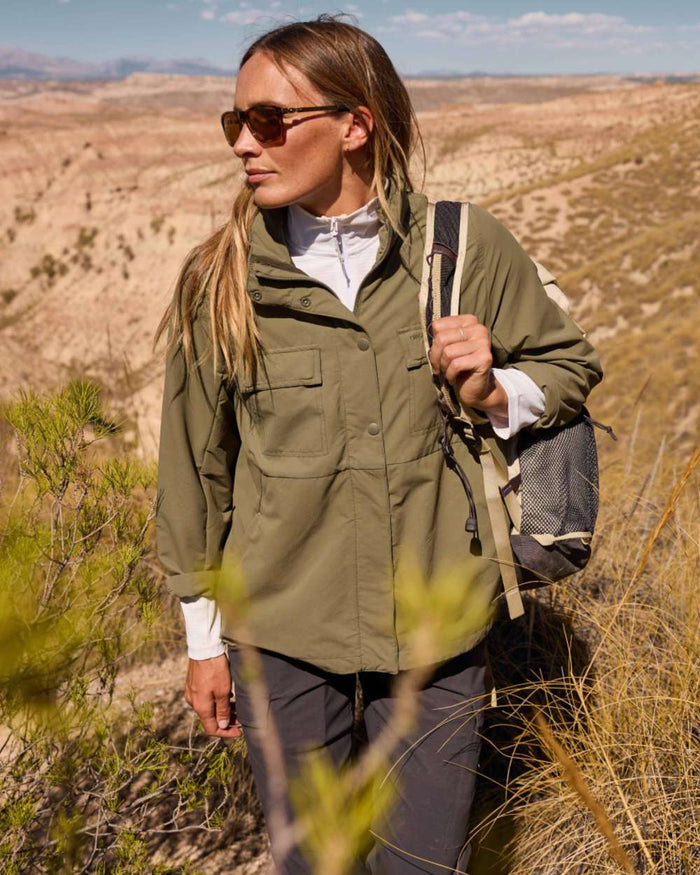 Wild Olive coloured Craghoppers Womens NosiLife Farah Jacket on mountain background #colour_wild-olive