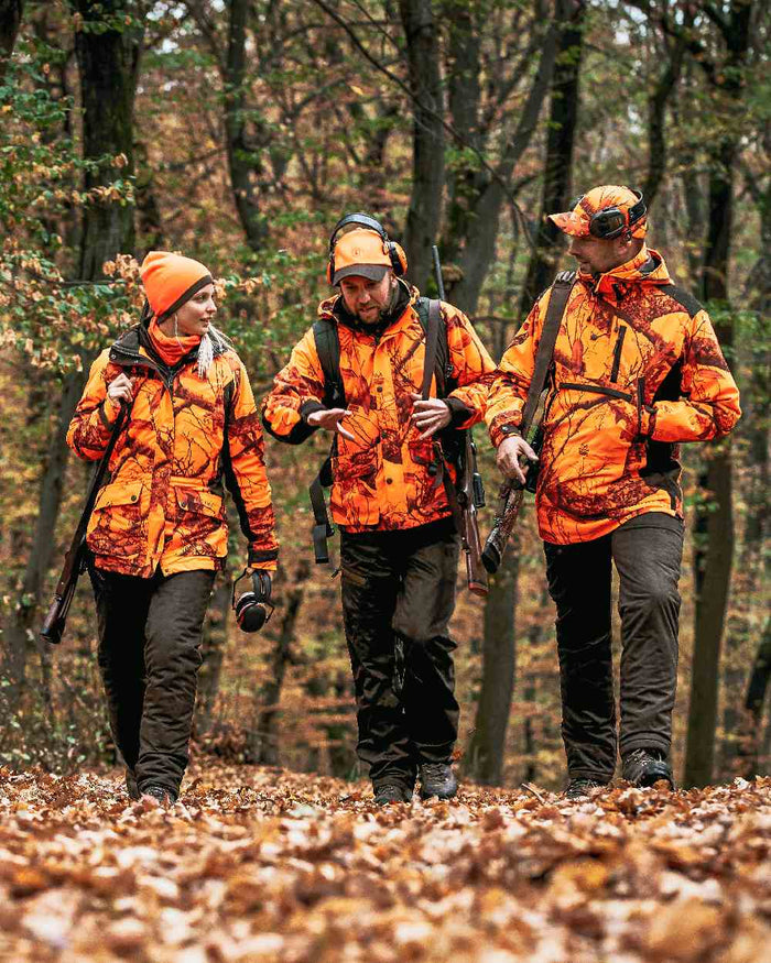 Orange Green coloured Deerhunter Cumberland Reversible Beanie on forest background #colour_orange-green