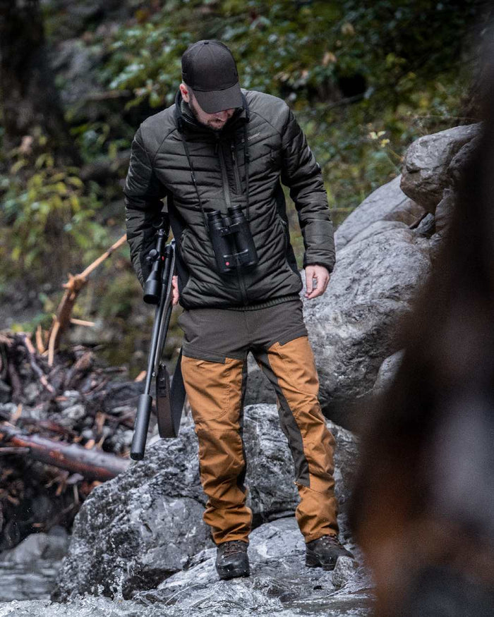 Adventure Green coloured Deerhunter Moor Padded Softshell Jacket on rock background #colour_adventure-green