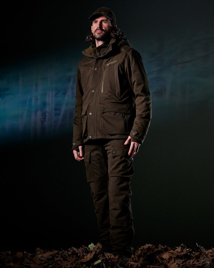 Art Green coloured Deerhunter Mens Muflon Pro Trousers on forest background #colour_art-green