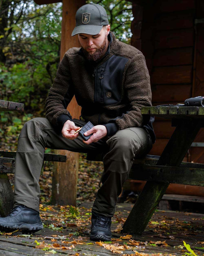 Bark Green coloured Deerhunter Northward Trousers on Forest Background #colour_bark-green