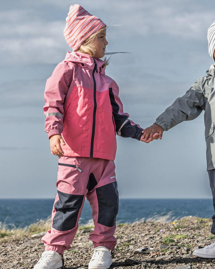 Heather Pink coloured Didriksons Childrens Dusk Pants on sea background #colour_heather-pink