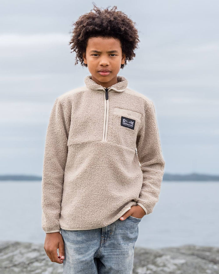 Beach Beige coloured Didriksons Childrens Exa Half Zip Sweater on sea background #colour_beach-beige