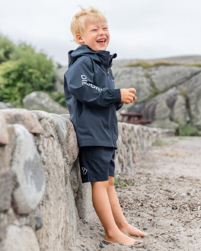 Navy coloured Didriksons Childrens Hallon Jacket on beach background #colour_navy