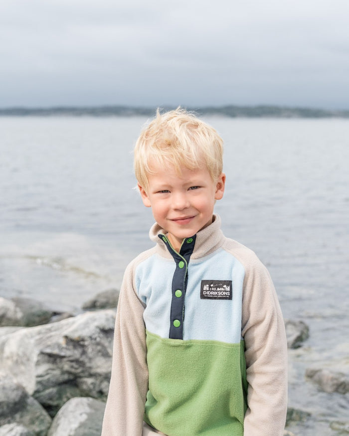 Algae Green coloured Didriksons Childrens Monte Half Button Fleece 4 on coastal background #colour_algae-green