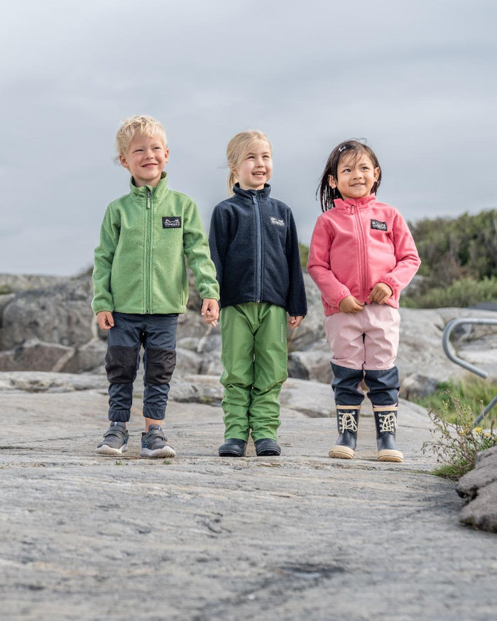 Algae Green coloured Didriksons Childrens Muskot Jacket on coastal background #colour_algae-green