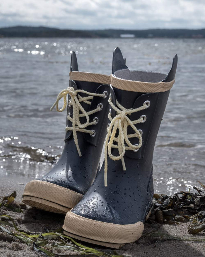 Navy Coloured Didriksons Childrens Splashman Boots On A Coastal Background #colour_navy