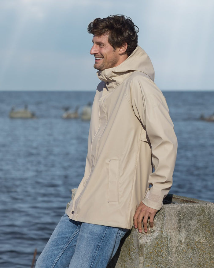 Clay Beige coloured Didriksons Mens Darwin Jacket on sea background #colour_clay-beige