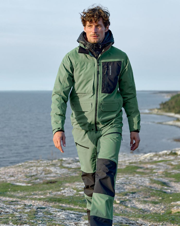 Dark Moss coloured Didriksons Fractus Waterproof Jacket on sea background #colour_dark-moss