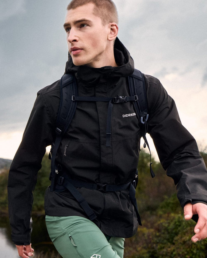 Black coloured Didriksons Mens Grit Jacket 4 on mountain background #colour_black
