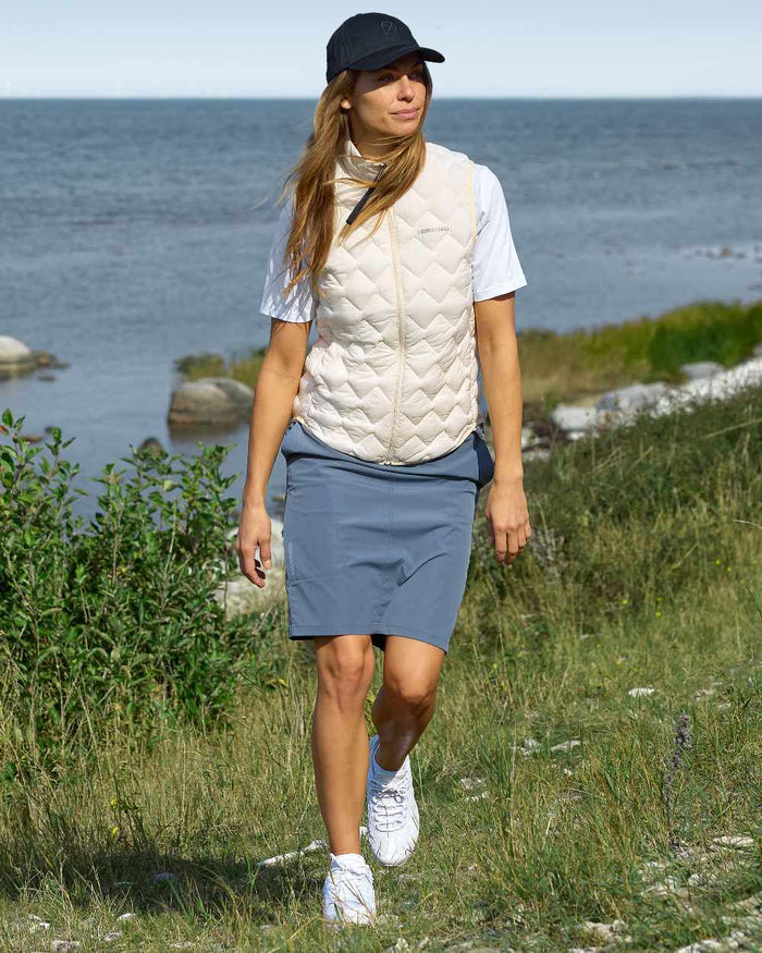 White Foam coloured Didriksons Womens Evy Vest on sea background #colour_white-foam