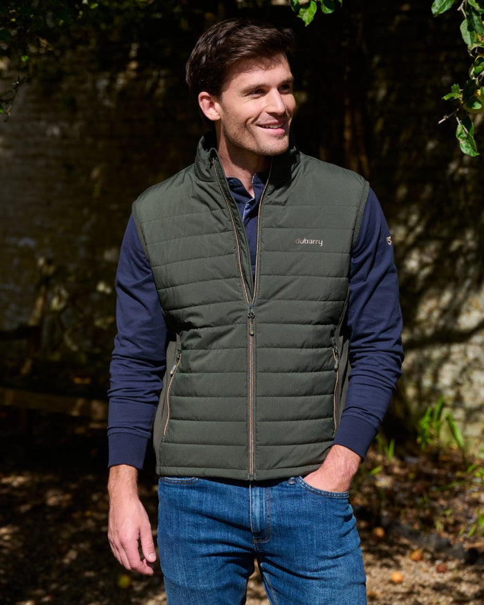 Olive coloured Dubarry Mens Solent Lightweight Hybrid Gilet on park background #colour_olive