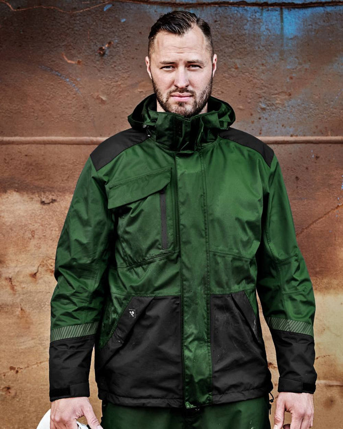 Green Black Coloured Elka Mens Working Xtreme Stretch Jacket on construction background #colour_green-black
