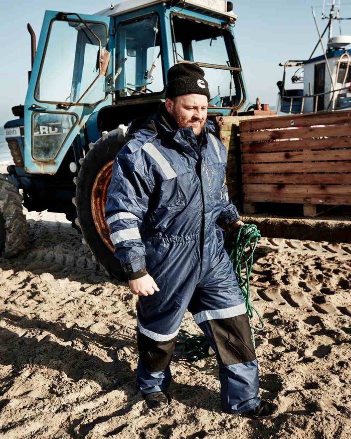 Blue Black Coloured Elka Mens Working Xtreme Winter Thermal Coverall on tractor background #colour_blue-black