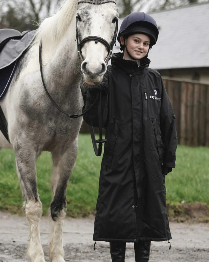 Black coloured Equidry Children Pro Ride Evolution Thin Fleece With Stowaway Hood on farm background #colour_black