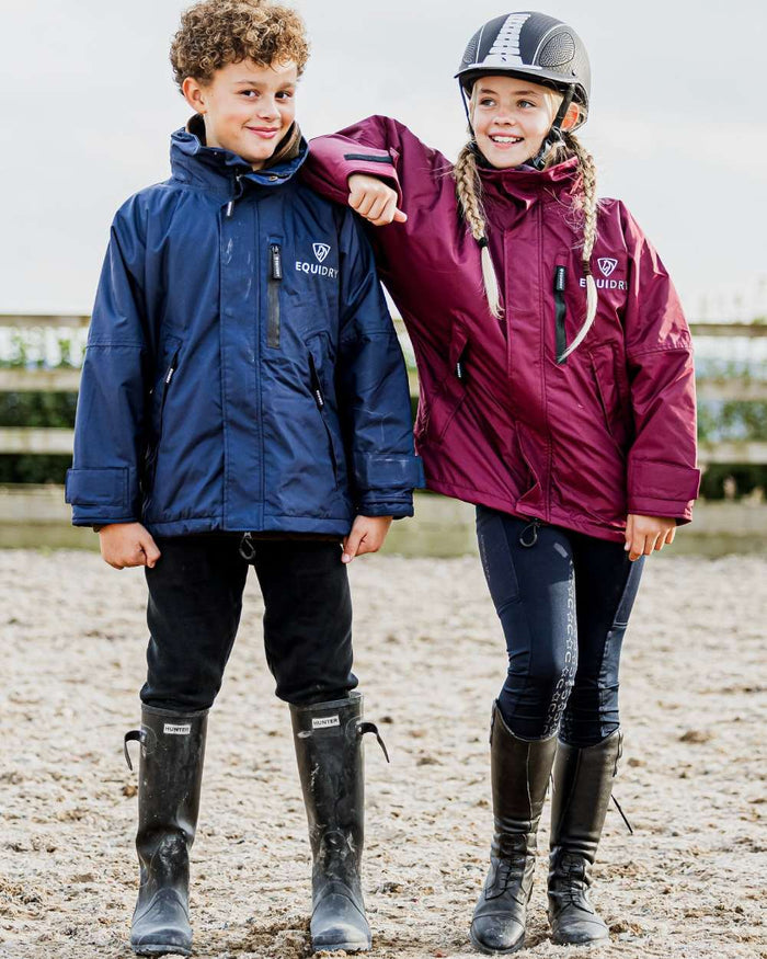 Plum coloured Equidry Childrens Shortie Jacket on street background #colour_plum