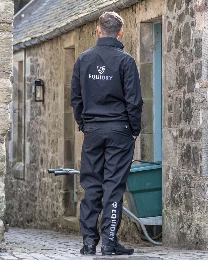 Black coloured Equidry Mens Fleece Lined Waterproof Trousers on outdoor background #colour_black
