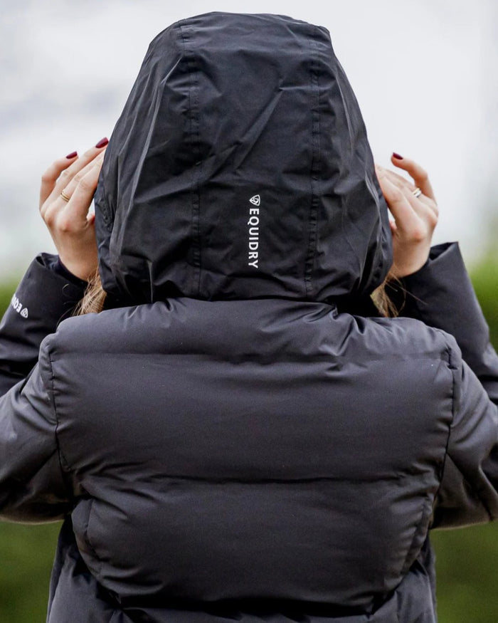 Black coloured Equidry Thora Waterproof Riding Puffer Coat With Hood on outdoor background #colour_black