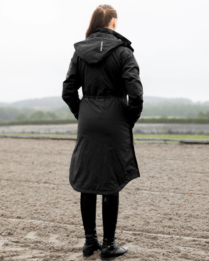 Black Coloured Equidry Womens Bronte Riding Coat With Removable Hood on outdoor background #hood_removable #colour_black