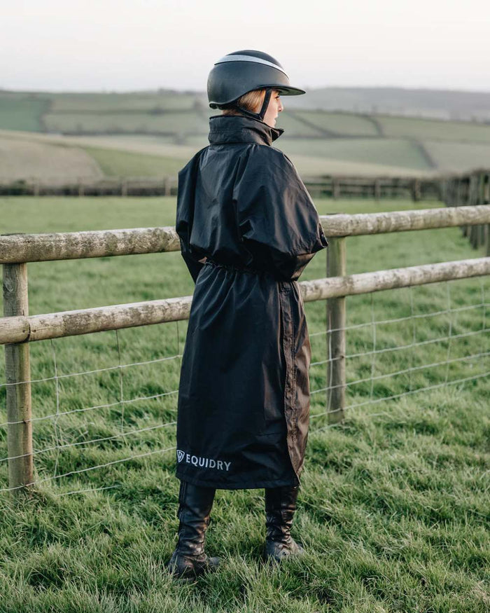 Black coloured Equidry Womens Equimac Evolution Jacket on farm background  #colour_black