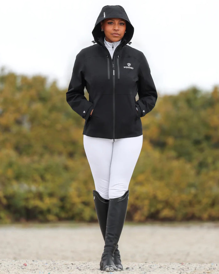 Black coloured Equidry Womens Varsha Jacket with Stowaway Hood on sand background #colour_black