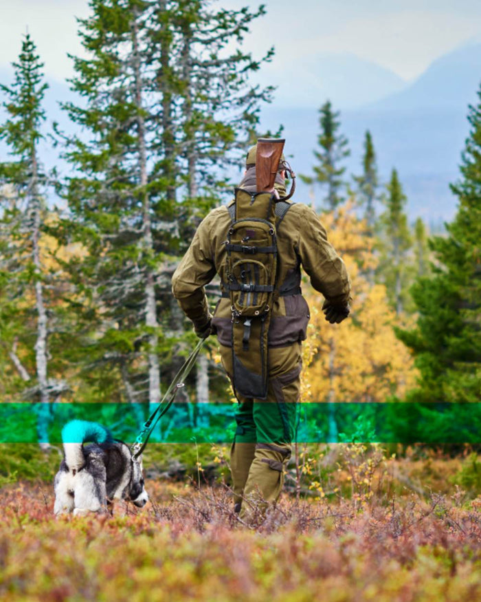 Hunting Green Coloured Harkila Alta Rucksack In Melton Wool on forest background #colour_hunting-green