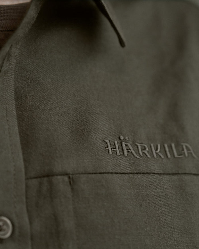 Willow Green Coloured Harkila Alto Long Sleeve Shirt on outdoor background #colour_willow-green