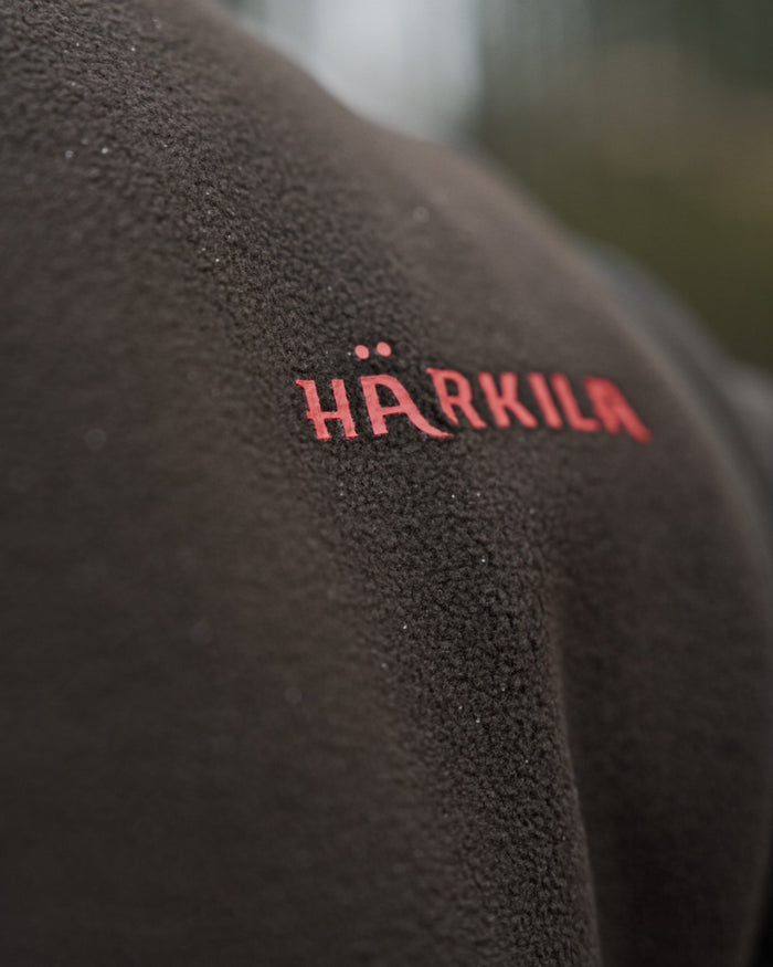 Shadow Brown Coloured Harkila Aspire Fleece Waistcoat on outdoor background #colour_shadow-brown