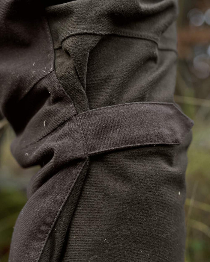 Hunting Green Shadow Brown Coloured Harkila Aspire HWS Trousers on forest background #colour_hunting-green-shadow-brown