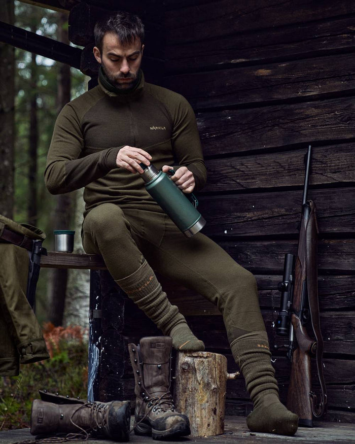 Willow Green Shadow Brown Coloured Harkila Base Warm Zip Neck on countryside background #colour_willow-green-shadow-brown