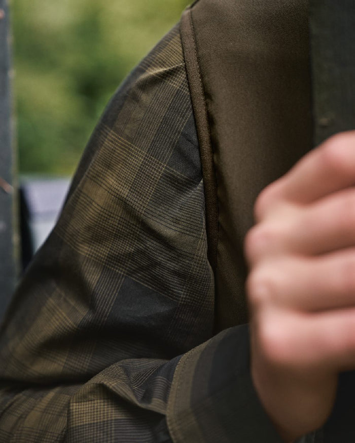 Hunting Green Willow Green Coloured Harkila Fjell Fleece Waistcoat on blurry background #colour_hunting-green-willow-green