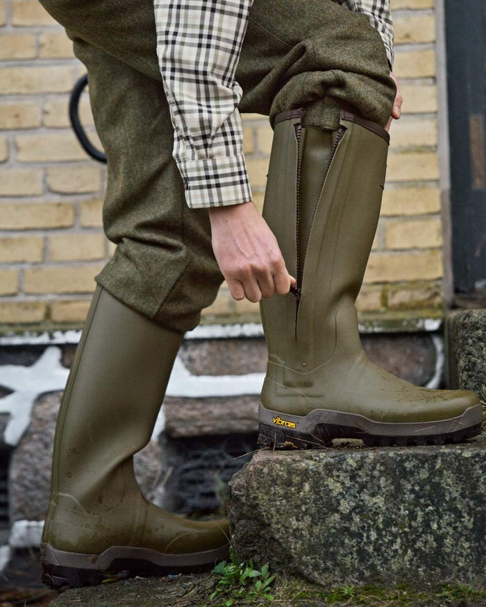 Dark Olive Coloured Harkila Forester Zip Rubber Boot on outdoor background #colour_dark-olive