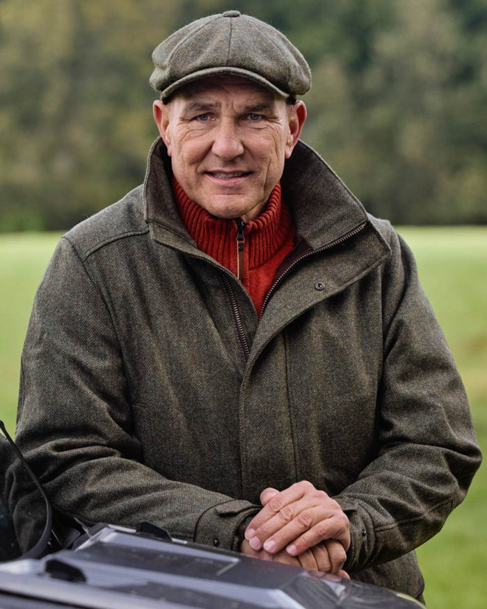 Forest Green Herringbone Coloured Harkila Kenmore Classic Baker Boy Cap on forest background #colour_forest-green-herringbone